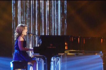 Anna Christine singing at the piano on stage