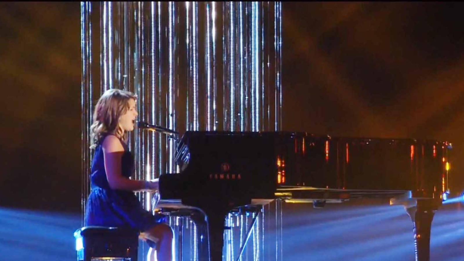 Anna Christine singing at the piano on stage